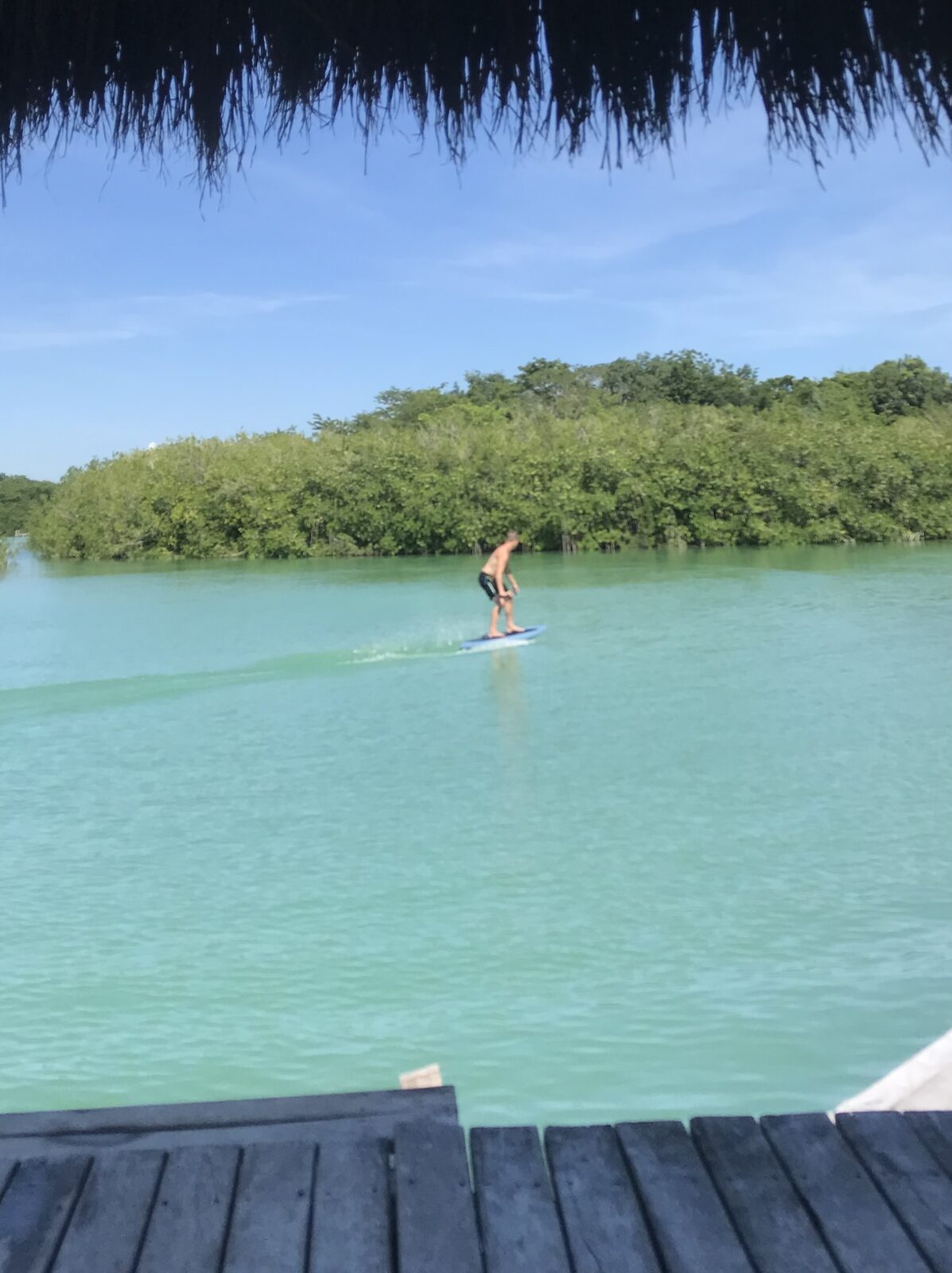 Foiling across flat turquoise lagoon water